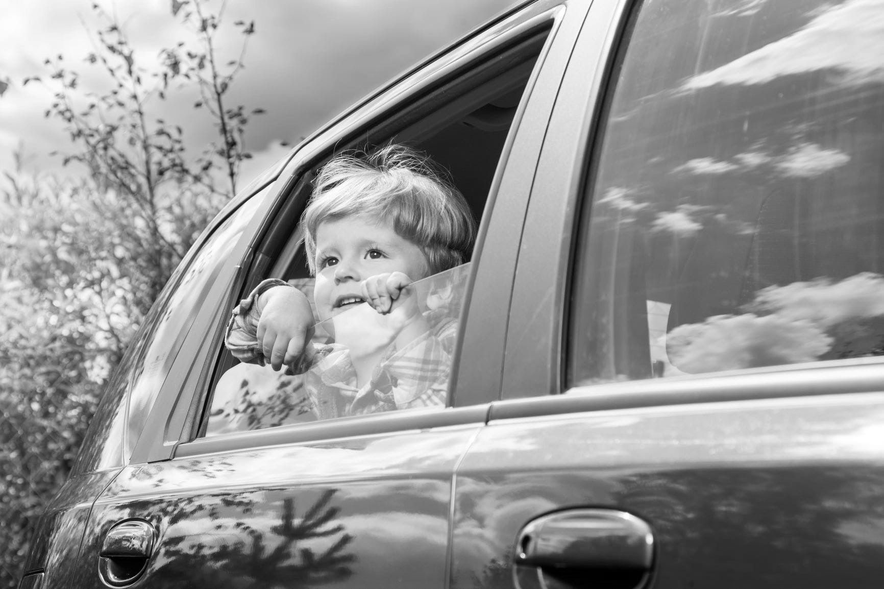 child sitting in car and looking out window